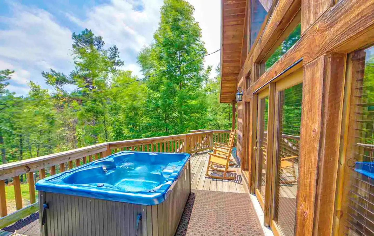 The porch is furnished with a bath tab, rocking chairs, and dining table.