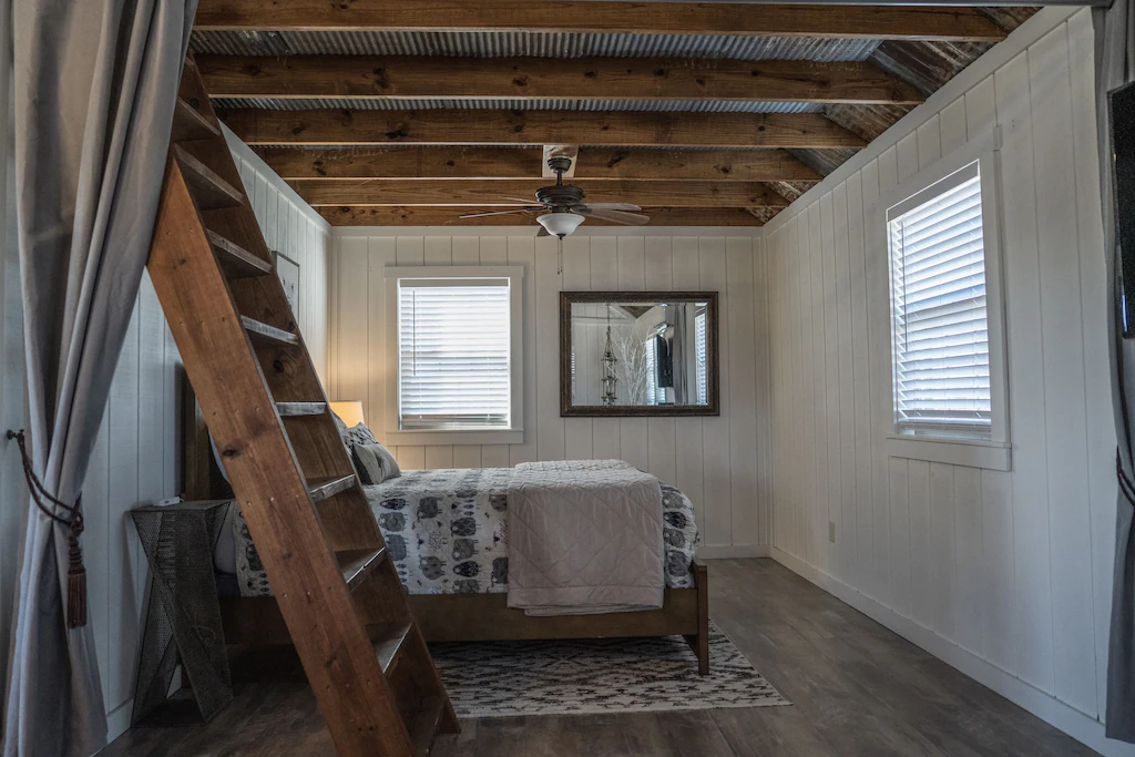 The farmhouse' master bedroom with the stairs leading to the loft.