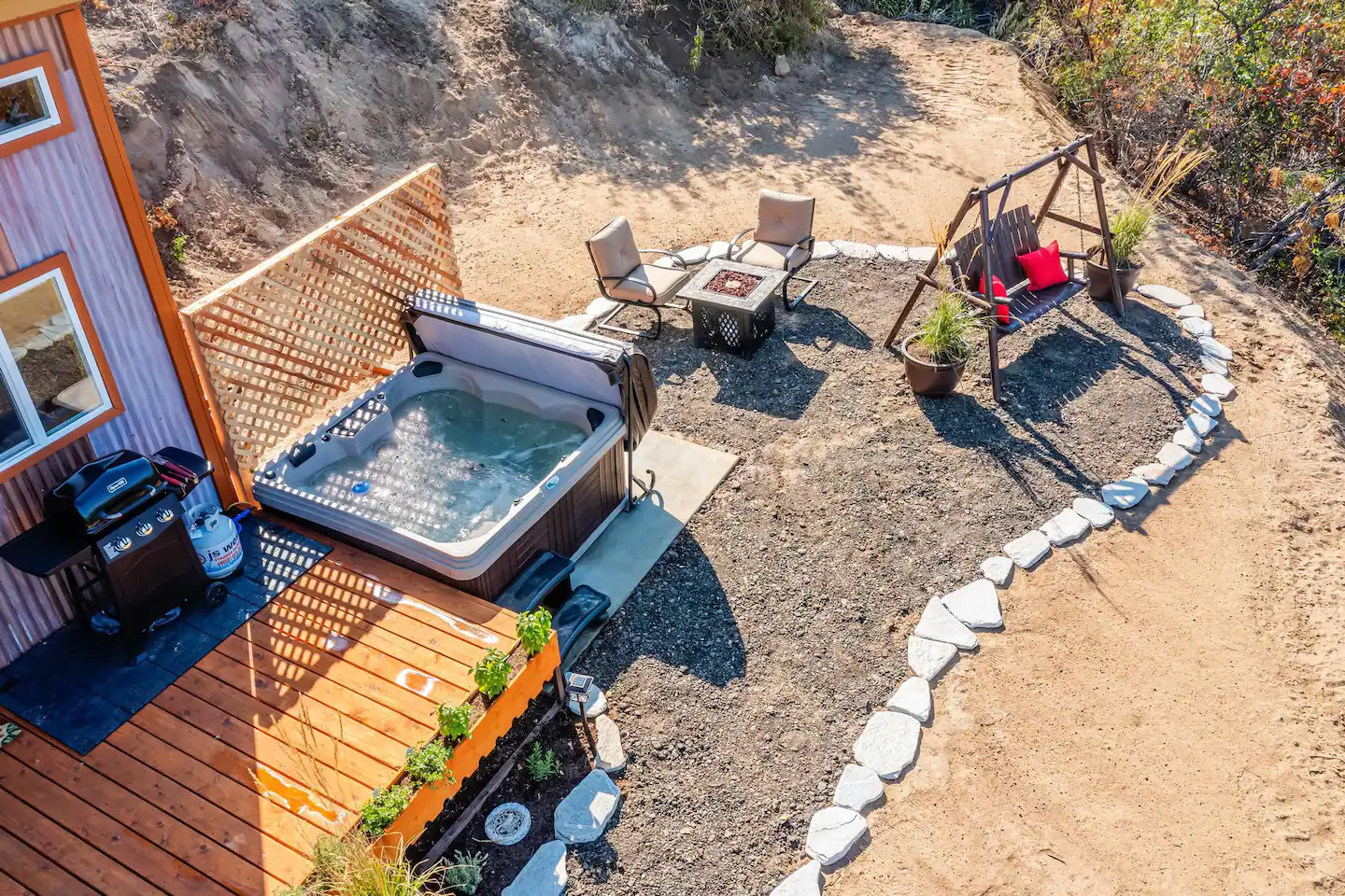 A comfortable hang out area with a hot tub, gas fire pit, and seat swing overlooking the wonderful landscape!
