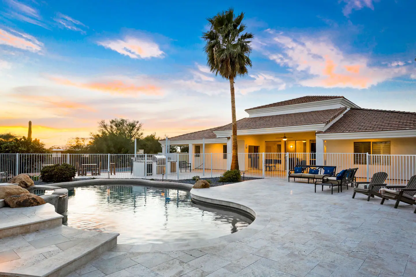 Swimming Pool with a palm tree and seating area nearby.