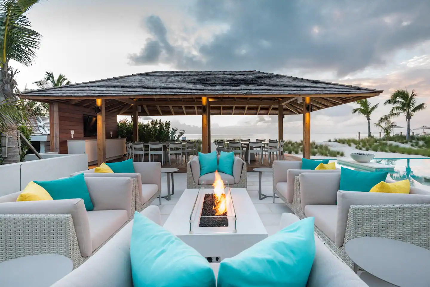 Serenely landscaped outdoor pool area with plush sofas for a relaxing day/night out.