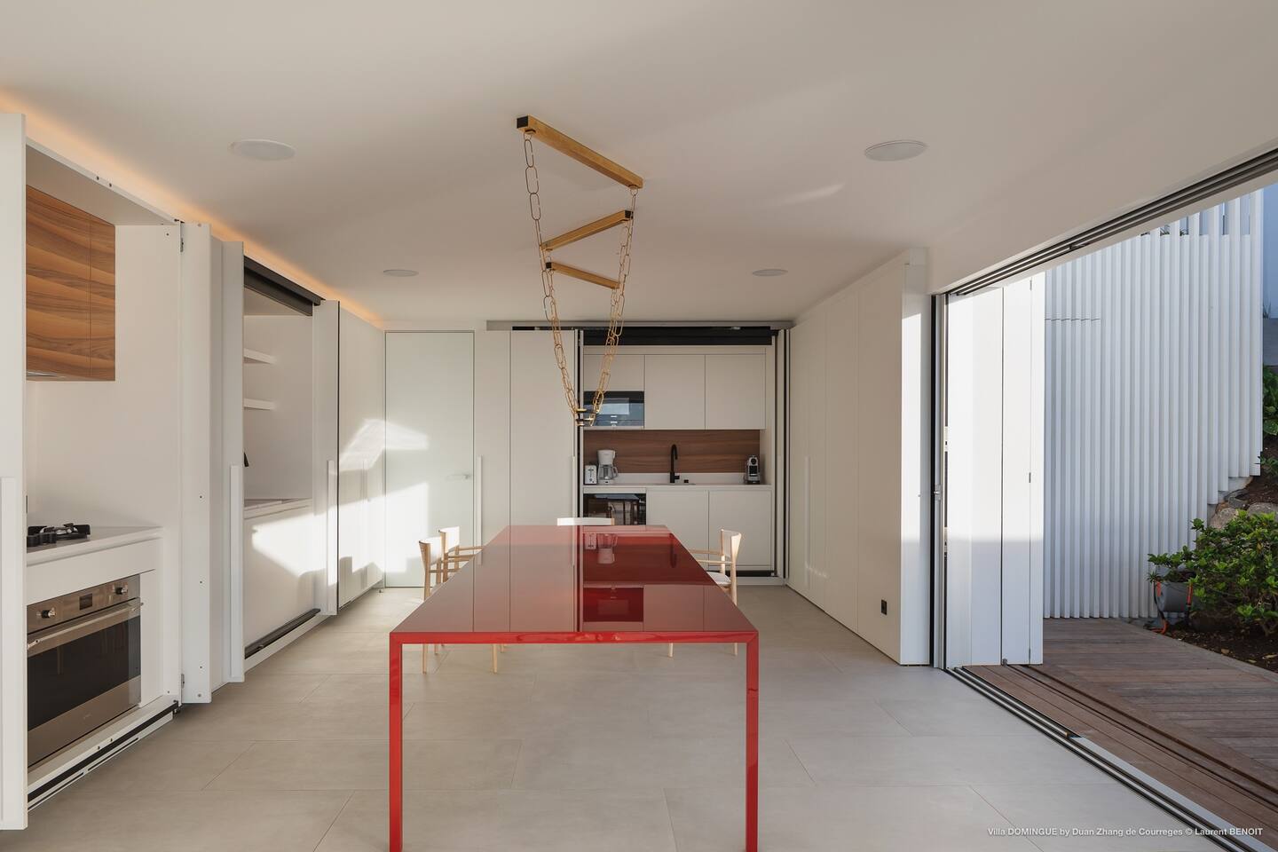 Spacious dining area showcasing a stunning designer table, adorned with elegant place settings.