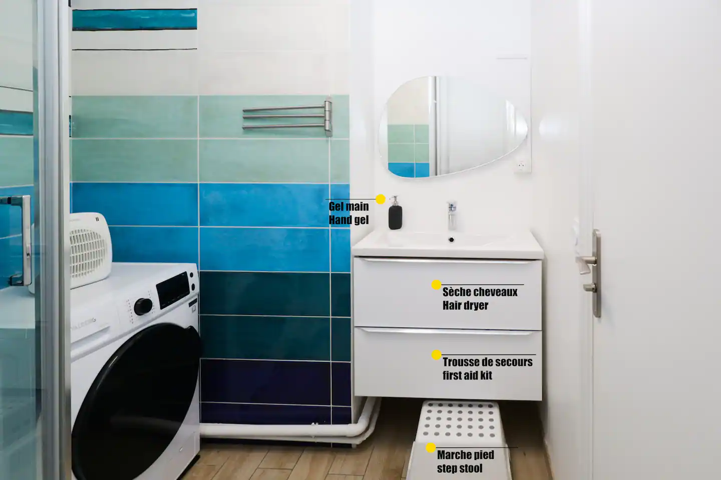 A contemporary bathroom with essential features for 7 people, including a toilet, hair dryer, washer and dryer, shower supplies, and towels.